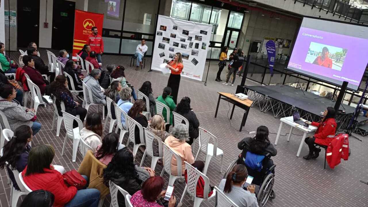 vista desde arriba del evento donde se ve la presentadora hablando frente a varias mujeres que asisten y están sentadas en silllas