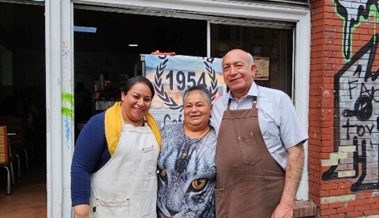 Los tres felices sonriendo frente a la panadería La Sultana