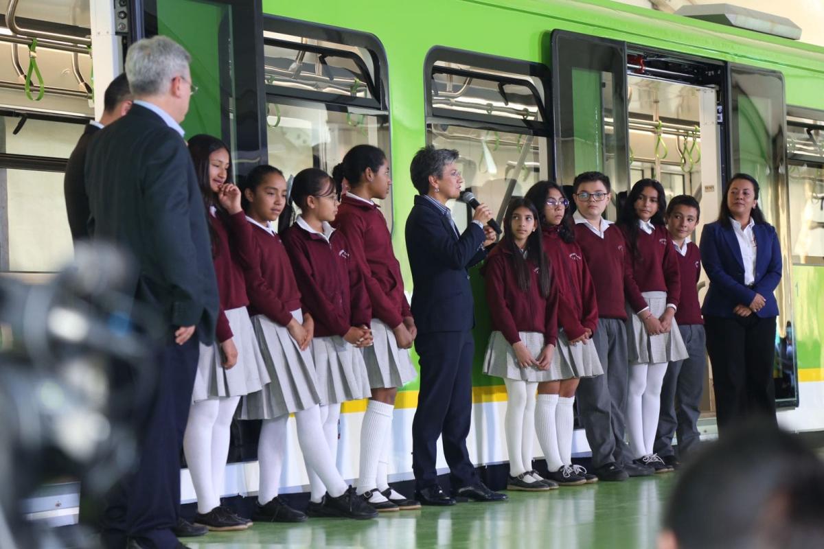 Alcaldesa hablando frente al vagón con varios niños