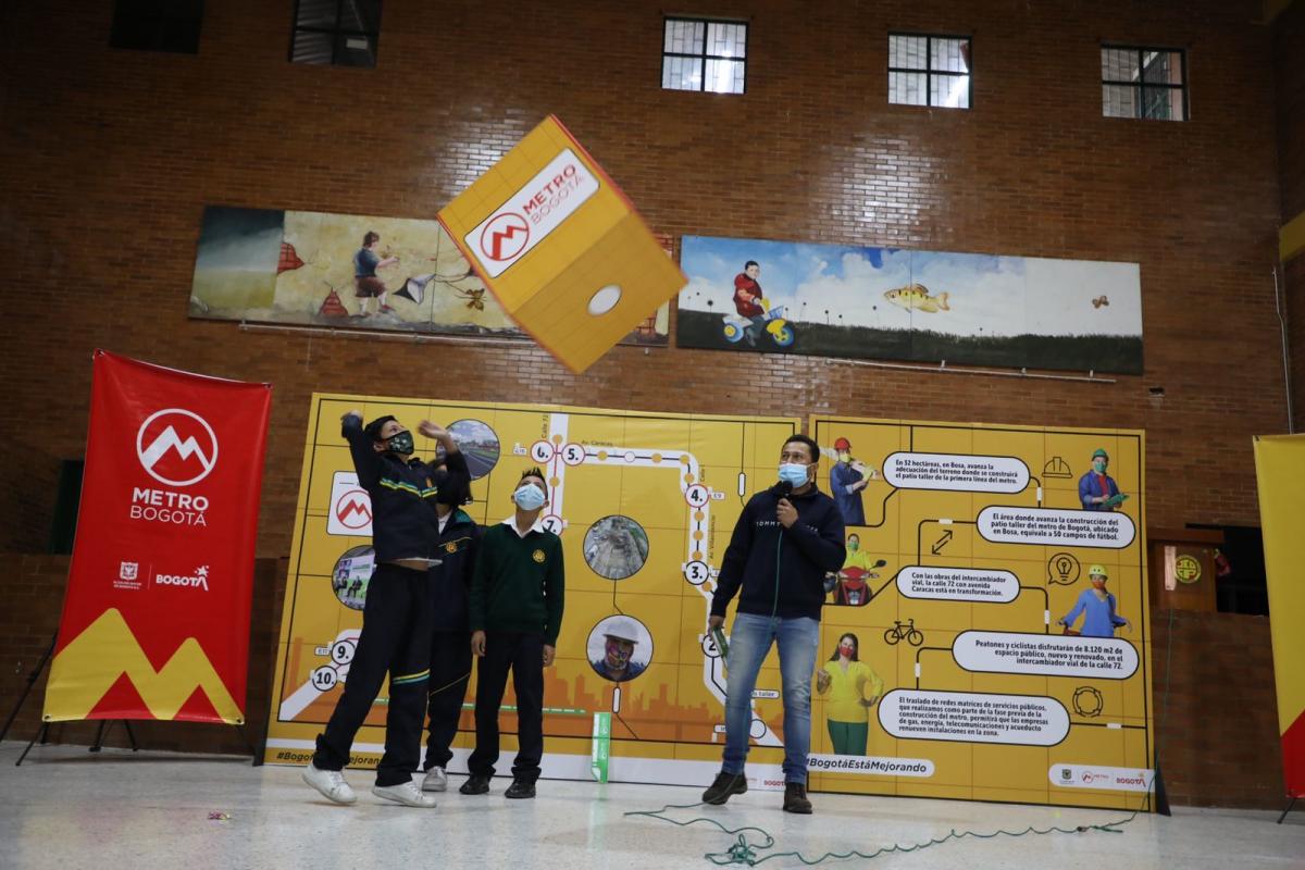 Niños lanzando un dado en el juego de Recorriendo Nuestro Metro
