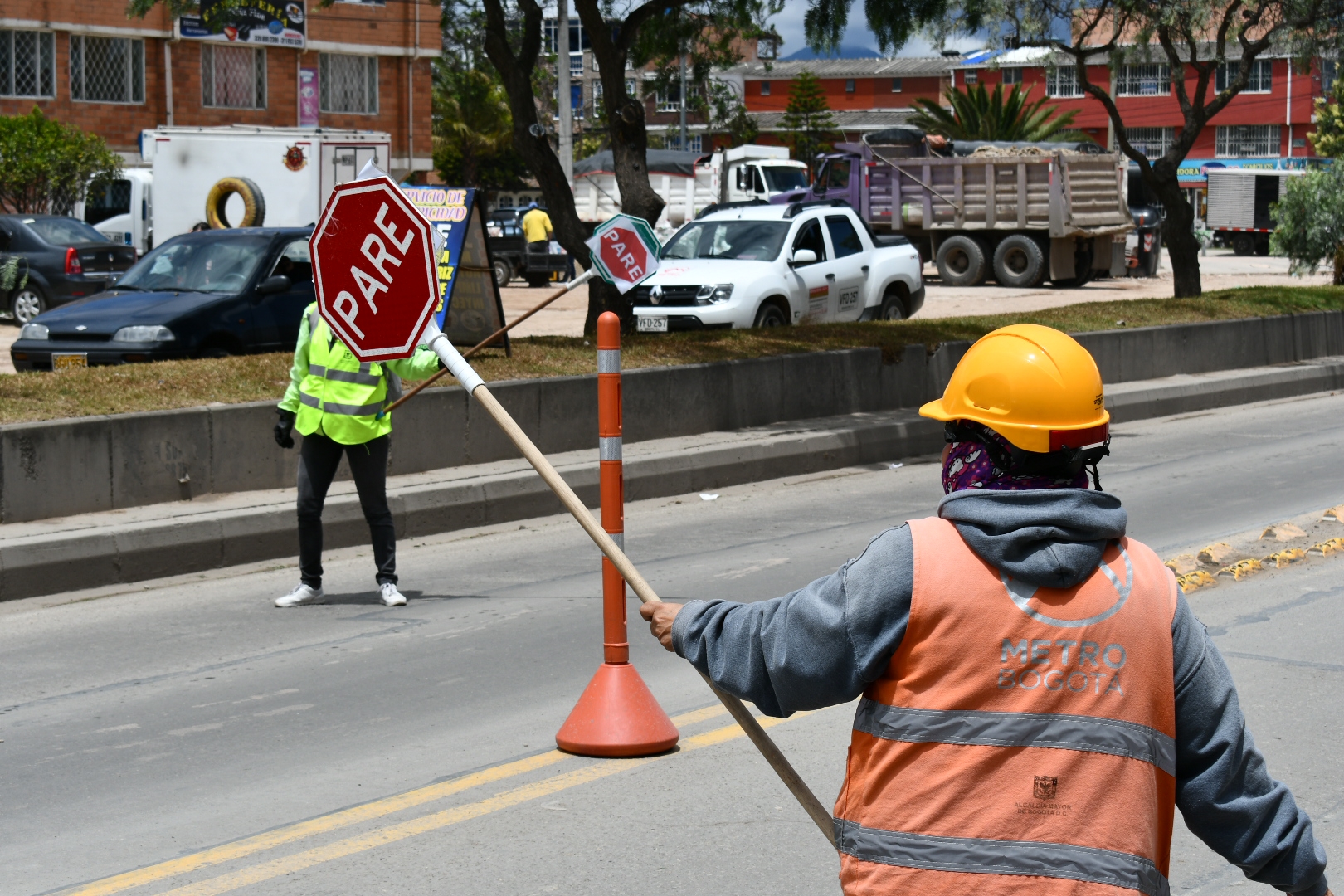 Auxiliares de tráfico en la vía sosteniendo las señales de tránsito para dar paso