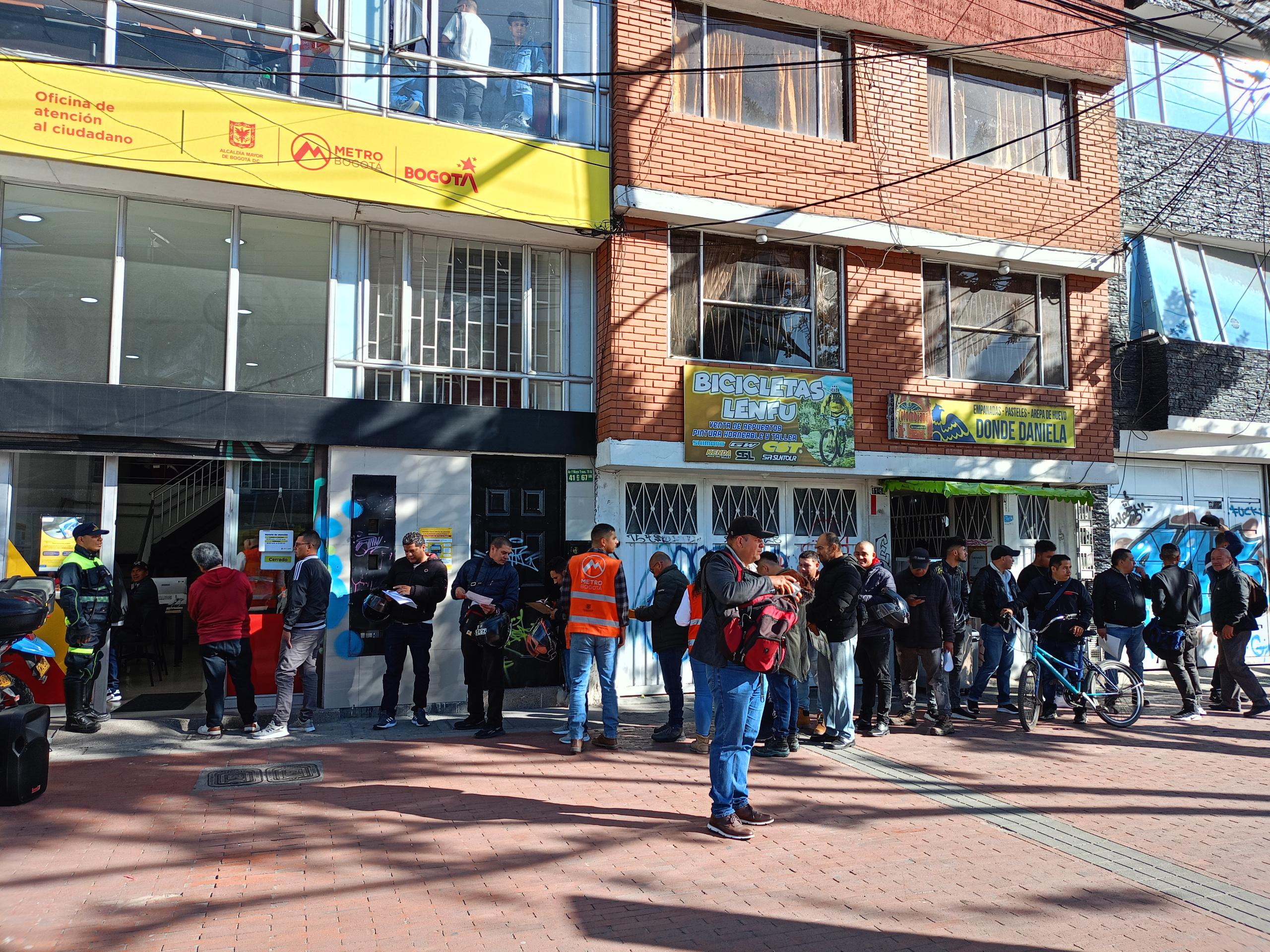 Fila de personas afuera de la oficina de atención a la ciudadanía