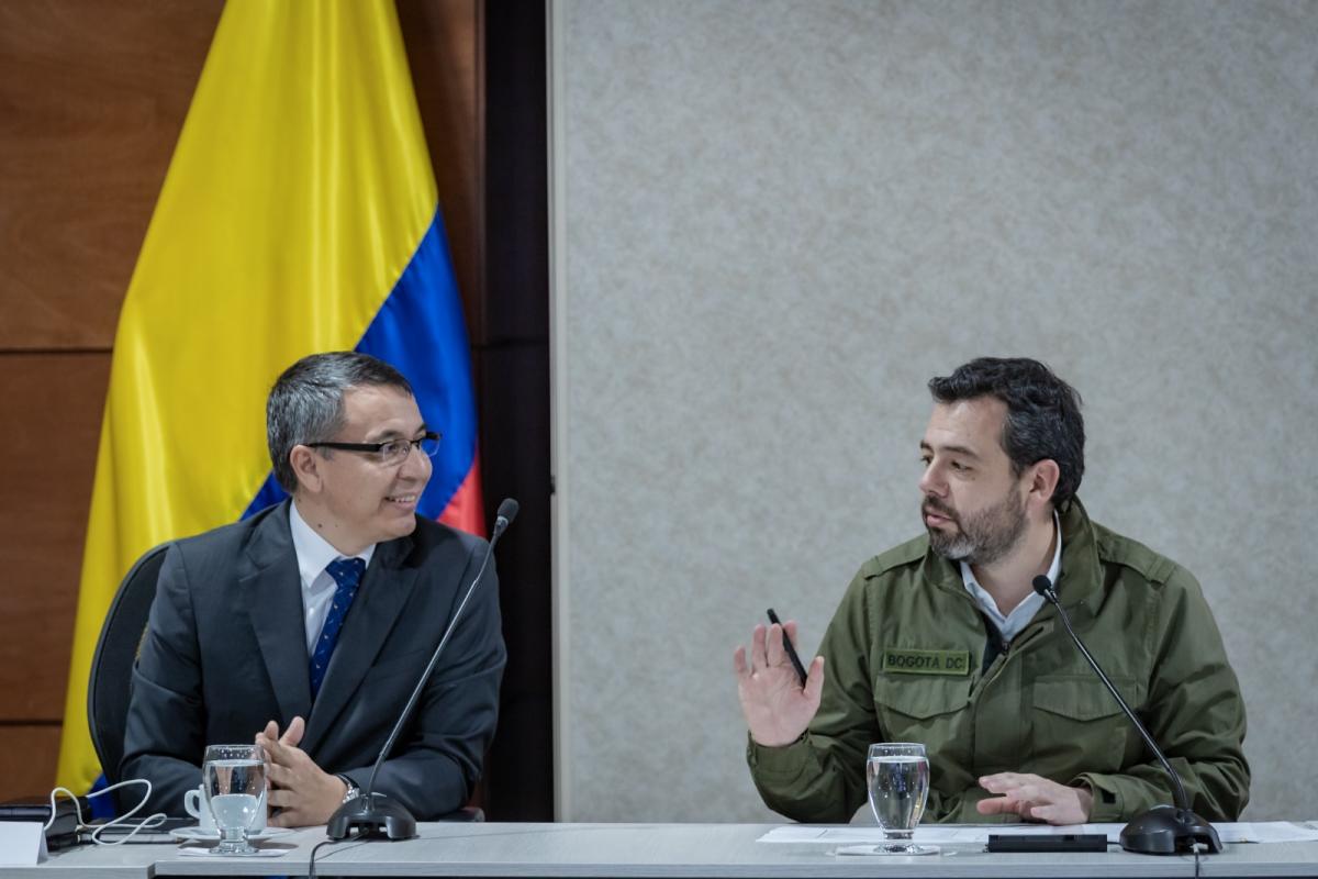 Ministro William Camargo sonriendo sentado junto al alcalde Carlos Galán