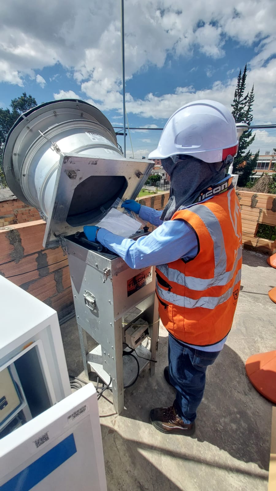 Trabajador del Metro abriendo la tapa de la estación de monitoreo del aire para hacer la revisión