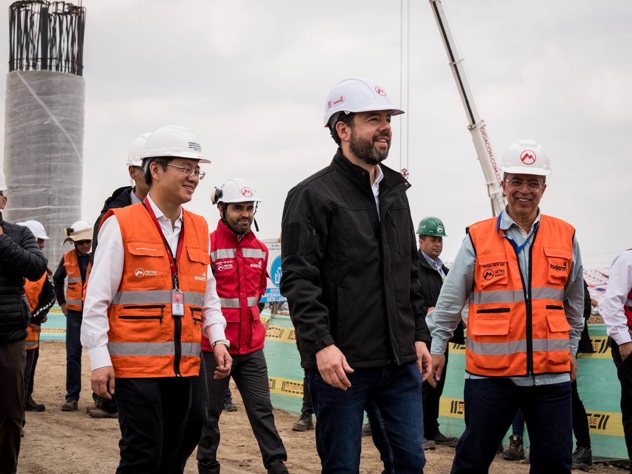 Alcalde caminando y sonriendo junto a Wu Yu del concesionario y Javier Descarga de interventoría