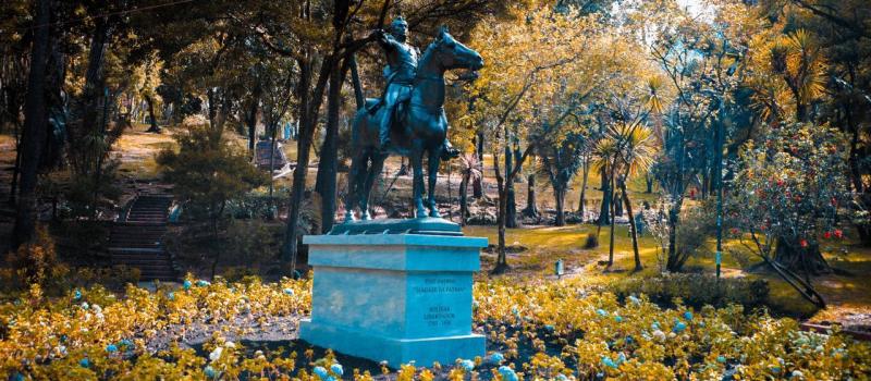 Vista frontal de la escultura del Bolívar ecuestre, rodeado por muchas hortensias en el Jardín de las Hortensias en el Parque de la Independencia