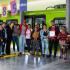 Un gestor social de la Empresa Metro posa sonriendo con los 34 vendedores informales en frente del Vagón del Metro de Bogotá