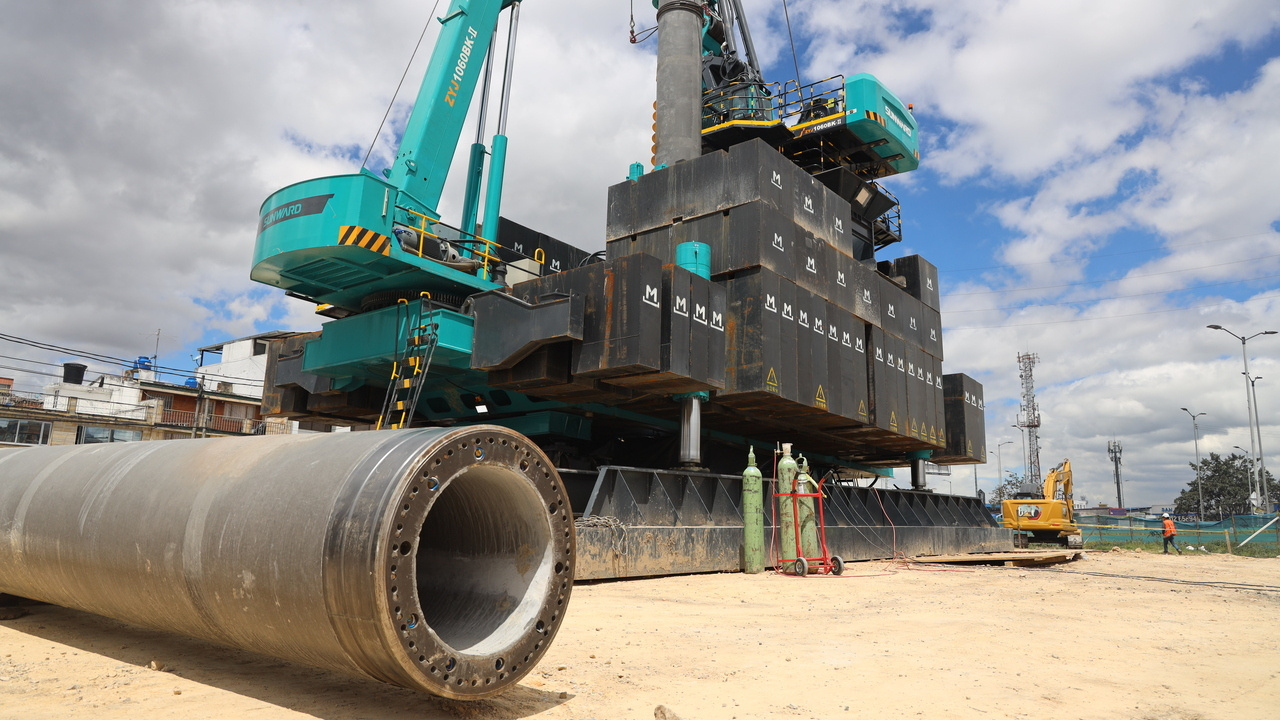 Piloteadora de hincado a presión en segundo plano y pilote PHC en primer plano