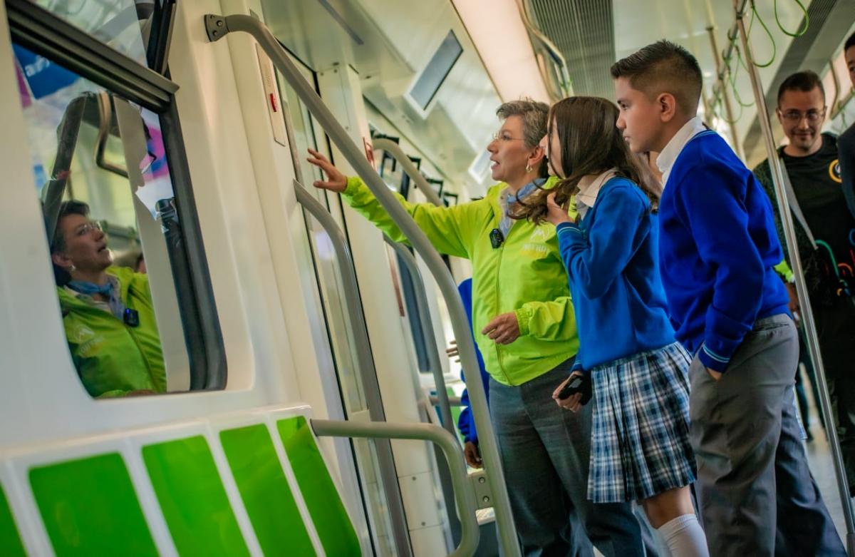 Alcaldesa Claudia Lopez mostrándole a algunos estudiantes la puerta del vagón de la Primera Línea del Metro de Bogotá